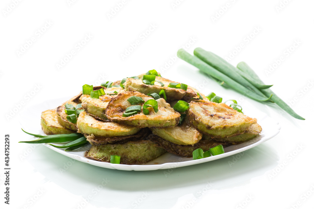 fried zucchini in circles with fresh herbs in a plate isolated on white fried zucchini in circles with fresh herbs in a plate isolated on white