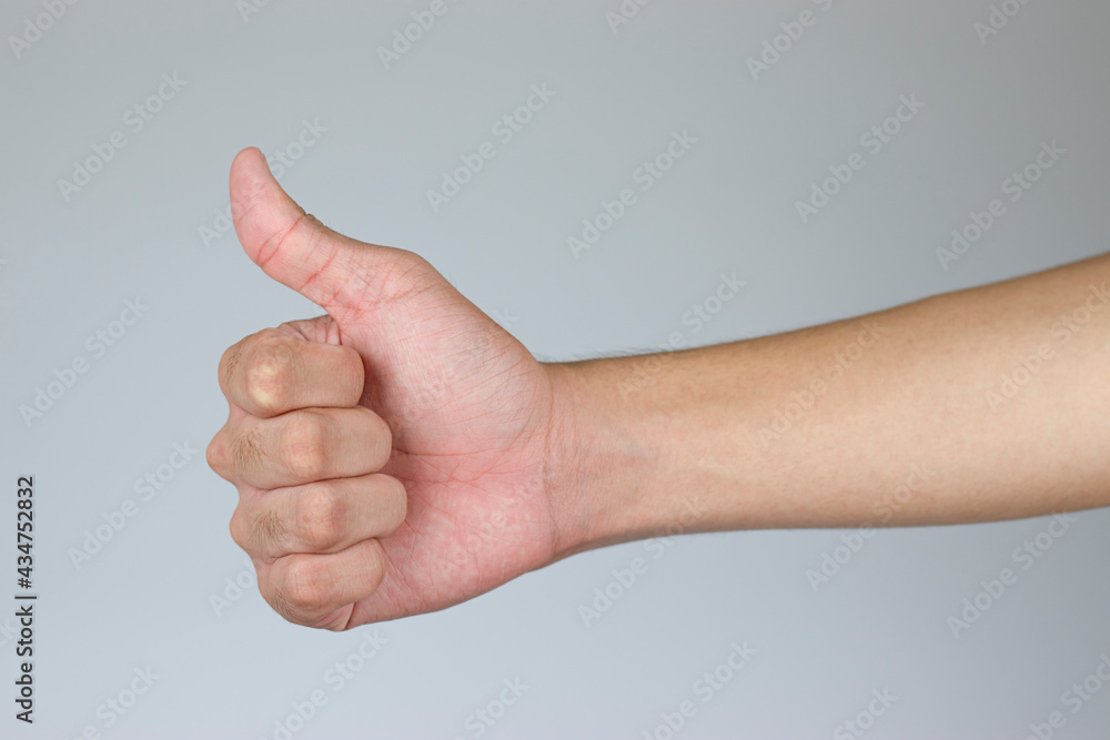The hand of a man who thumbs up to show the sign of appreciation. ( Clipping Path )
