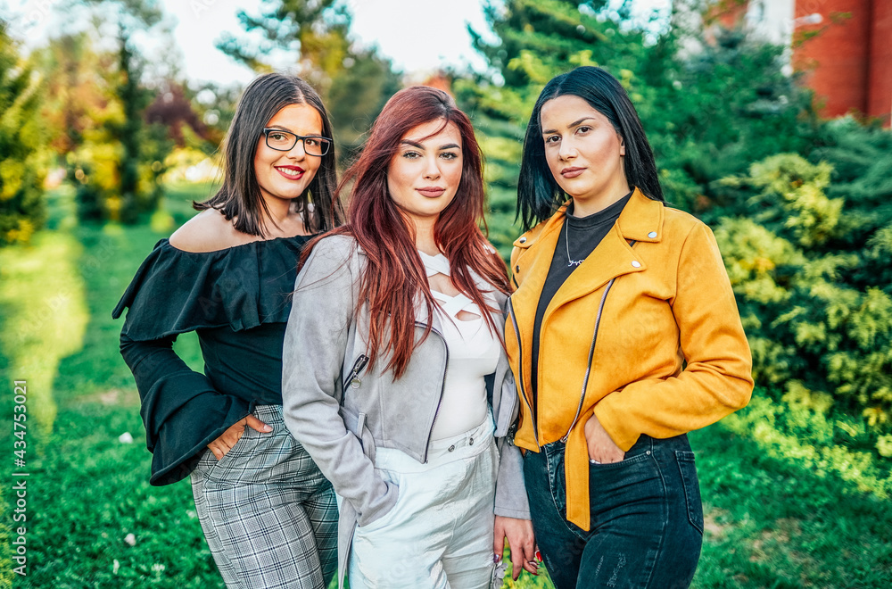 Three female friends posing in park Three female friends posing in park