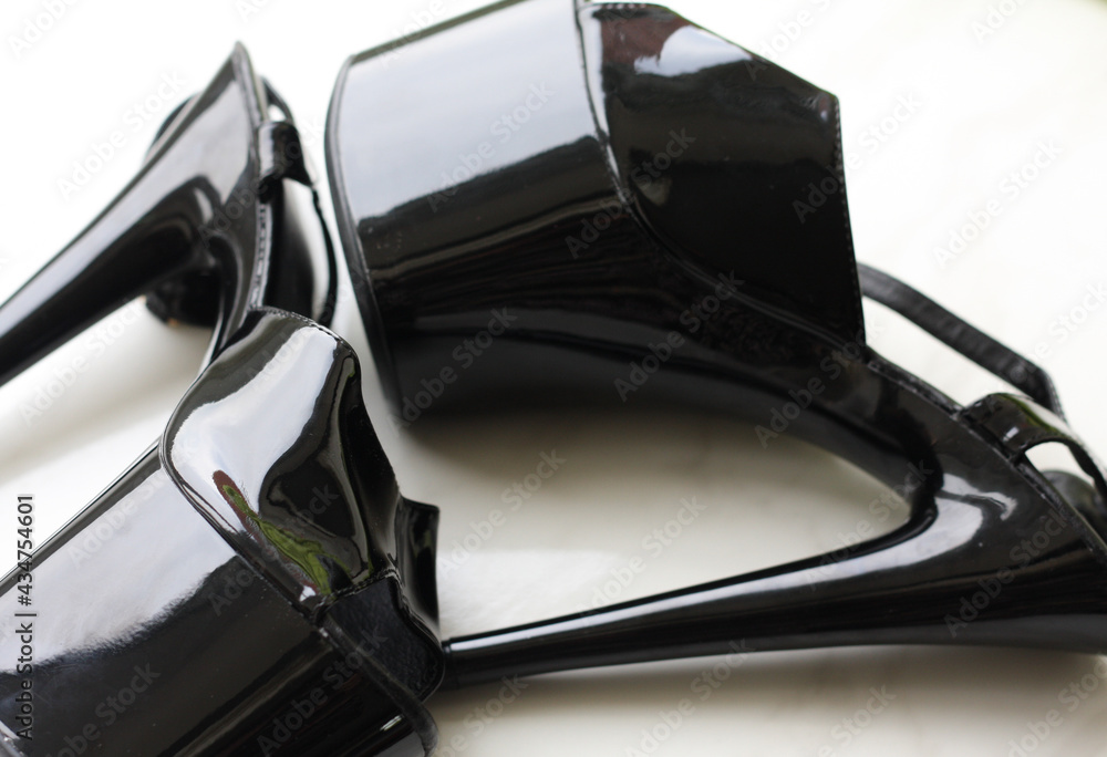 Black patent leather strips / high-heeled shoes on white background Black patent leather strips / high-heeled shoes on white background