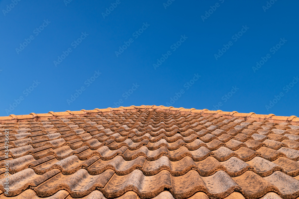 Close up of brown clay roof tiles. Red old dirty roof. Old roof tiles. Construction equipment build a house.