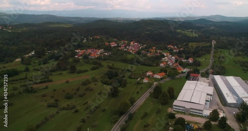 Aerial view away from a small town in cloudy, Slovenia- pull back, drone shot photo