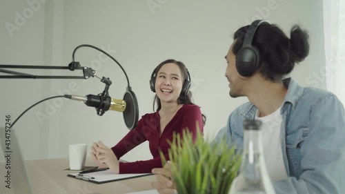 Smile two asian young woman, man radio hosts in headphones, microphone while talk, conversation, recording podcast in broadcasting at studio together. Technology of making record audio concept.