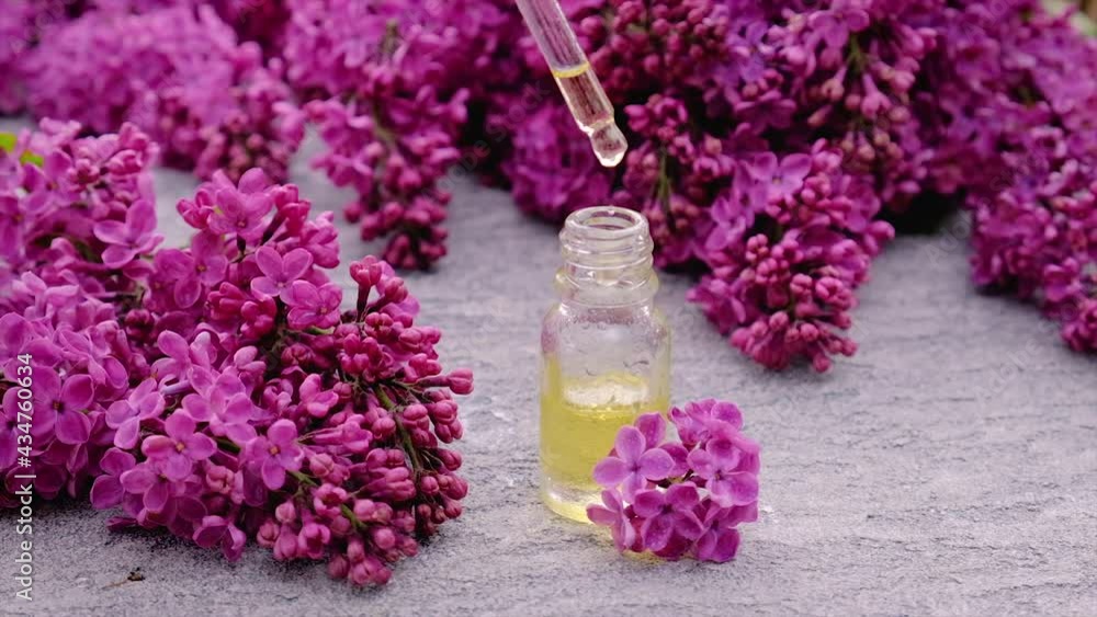 Lilac essential oil and extract in a small bottle. Selective focus. Lilac essential oil and extract in a small bottle. Selective focus.