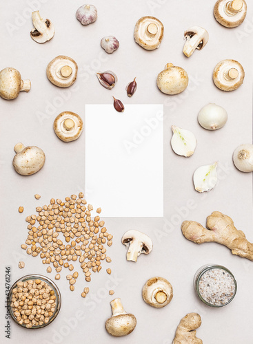 Chickpeas, mushrooms, onions and garlic, vegan recipe ingredients. White blank sheet of paper, various vegetables and grains. Flat lay with place for text. Healthy food concept