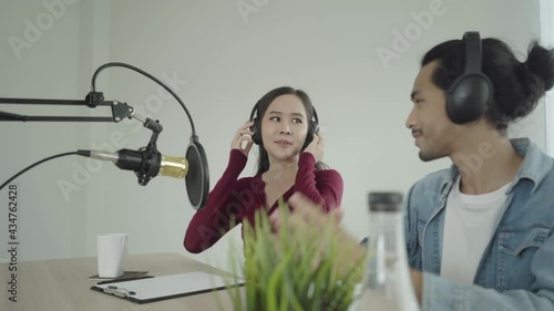 Smile two asian young woman, man radio hosts in headphones, microphone while talk, conversation, recording podcast in broadcasting at studio together. Technology of making record audio concept.