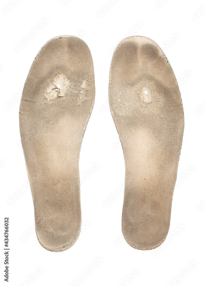 An old worn sneaker insole on a white background.The insole is full of holes and worn from the top view. An old worn sneaker insole on a white background.The insole is full of holes and worn from the top view.