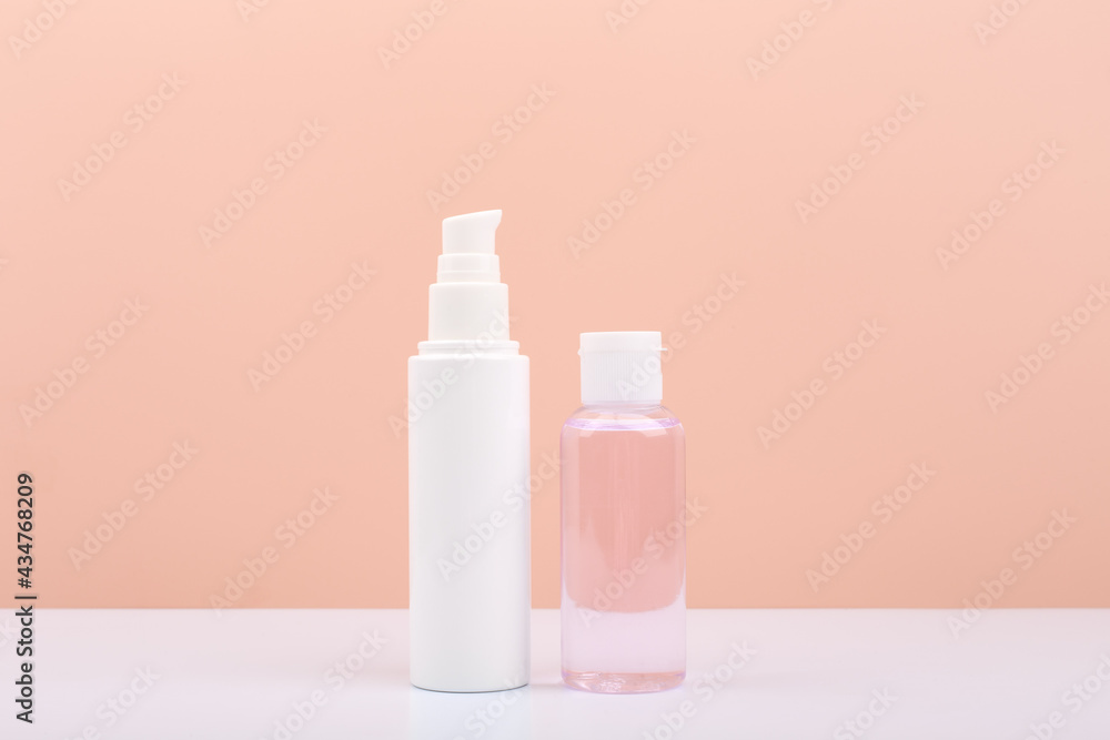 Cosmetic tubes with face cream and lotion for skin cleaning and exfoliating against bright pink background with copy space. Concept of daily skin care and beauty Cosmetic tubes with face cream and lotion for skin cleaning and exfoliating against bright pink background with copy space. Concept of daily skin care and beauty