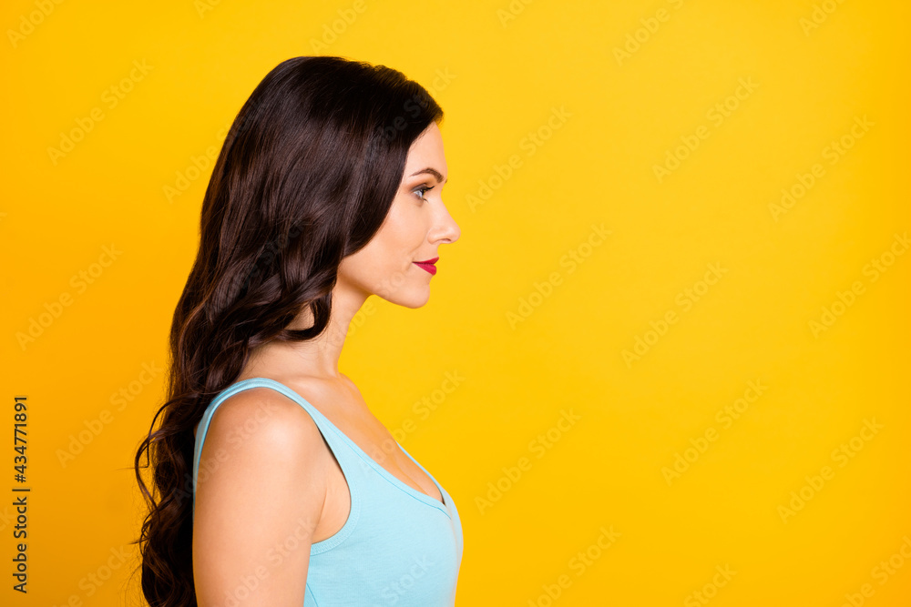 Profile photo of calm charming young girl look empty space wear blue top isolated yellow color background Profile photo of calm charming young girl look empty space wear blue top isolated yellow color background