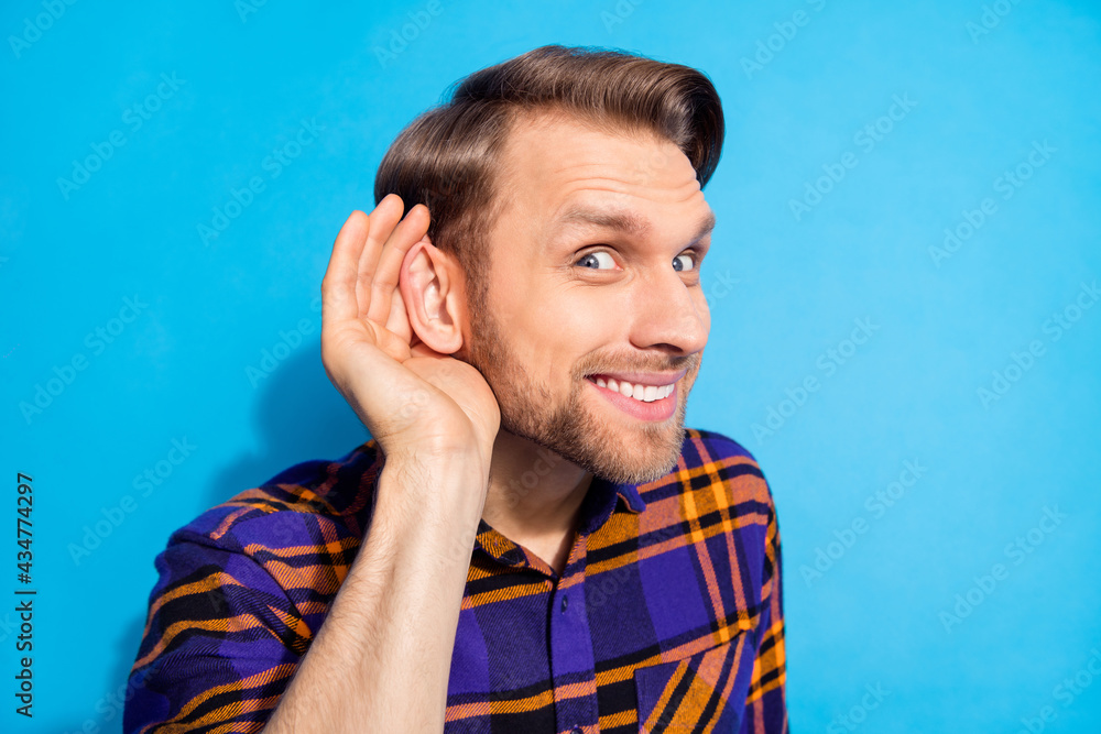 Photo of cheerful young man hold hand ear listen information curious isolated on pastel blue color background Photo of cheerful young man hold hand ear listen information curious isolated on pastel blue color background