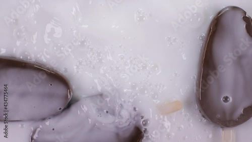 Popsicle ice cream falls into milk.