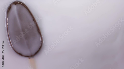 Popsicle ice cream falls into milk.