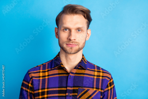 Photo of young man look attentively camera no emotions wear plaid isolated on blue color background