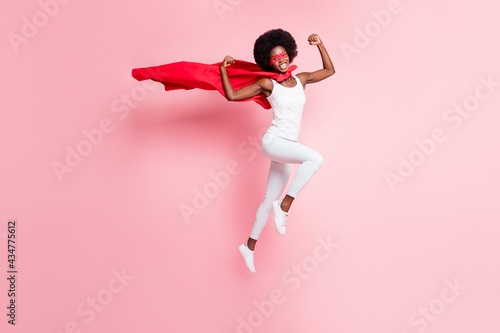 Obraz na plátne Full length body size view of cheery girl jumping wearing hero costume showing s