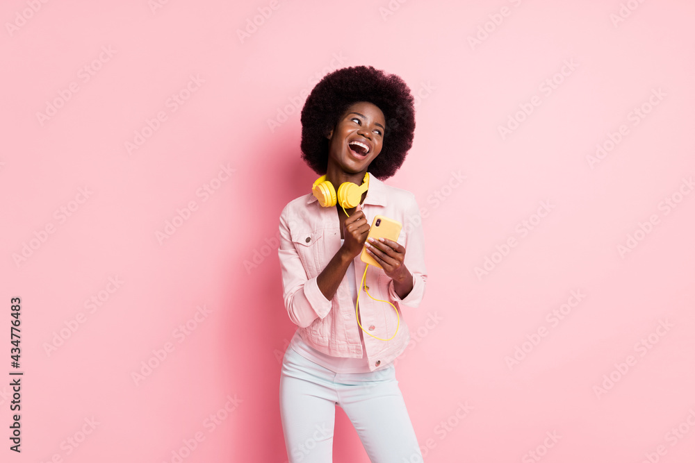 Portrait of pretty cheerful glad girl using device listening pop single dancing having fun isolated over pink color background Portrait of pretty cheerful glad girl using device listening pop single dancing having fun isolated over pink color background