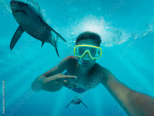 Junge macht ein Selfie im Meer und wird von Haien verfolgt © createyour.photo