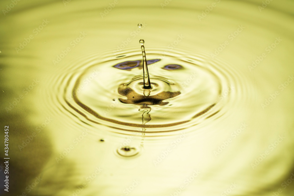 Macro view of drops making circles on water surface isolated on background.