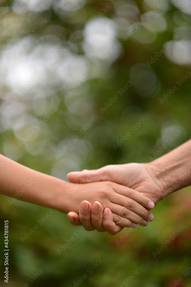 person holding granddaughter's hand person holding granddaughter's hand