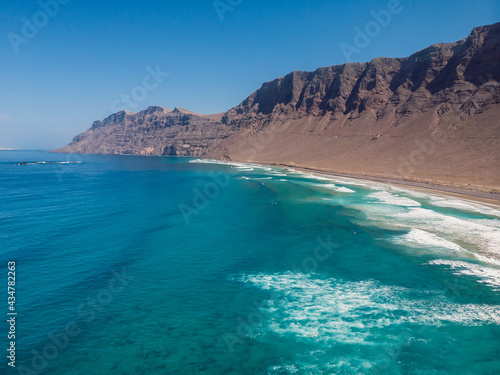 Aerial view of Famara beach with scenic landscape, blue ocean and mountains in Lanzarote