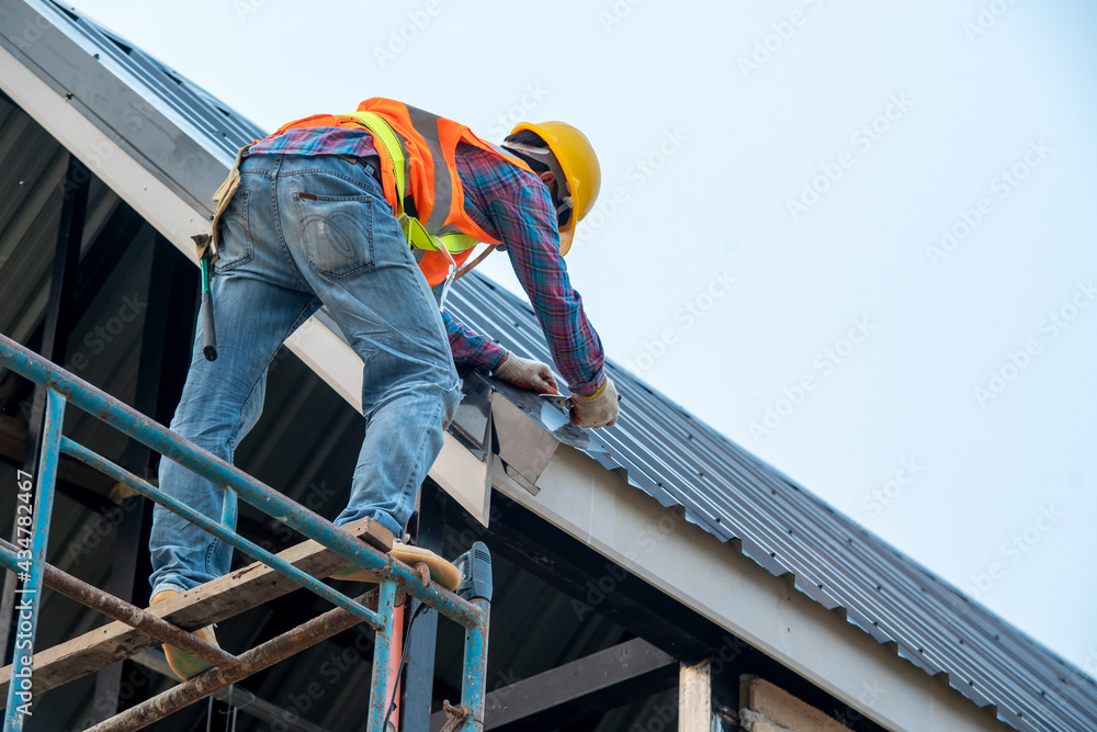 Construction worker install new roof,Roofing tools,Roofer working on roof structure of building on construction site.