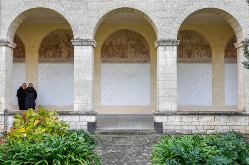 Lay man and benedictine monk in San Pietro di Sorres basilica cloister, Sardinia, Italy