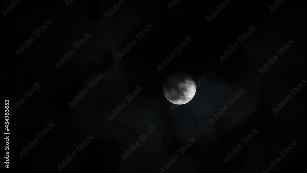 Full moon in the dark sky with clouds passing by Full moon in the dark sky with clouds passing by
