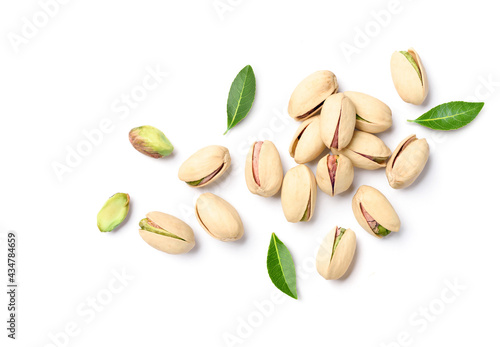 Flat lay of pistachio nuts with leaves on a white background. photo
