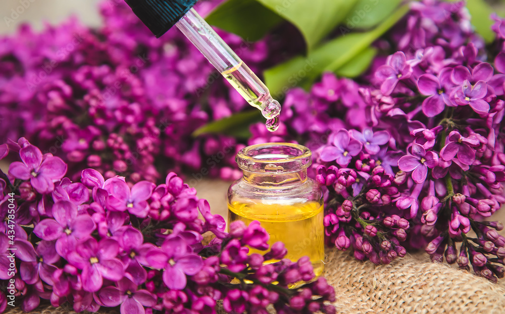 Lilac essential oil in a small bottle. Selective focus. Lilac essential oil in a small bottle. Selective focus.