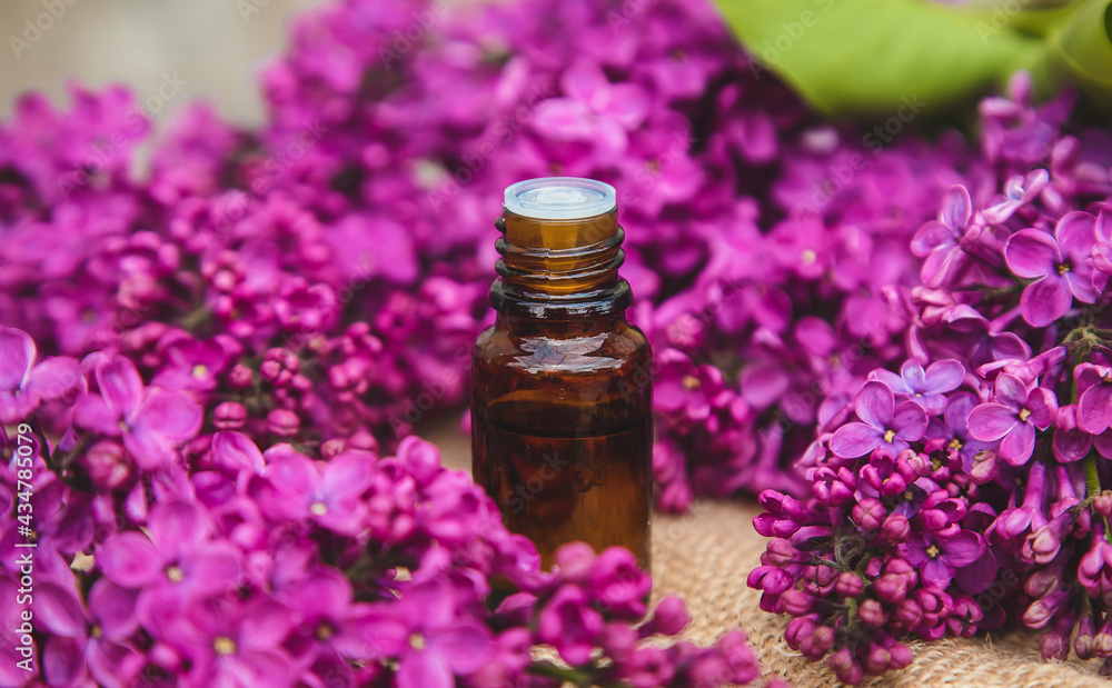 Lilac essential oil in a small bottle. Selective focus. Lilac essential oil in a small bottle. Selective focus.