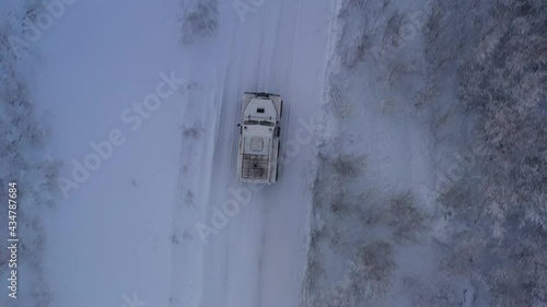 The six-wheel Trekol all-terrain vehicle rides through the snow-covered tundra in the sunset light
 photo