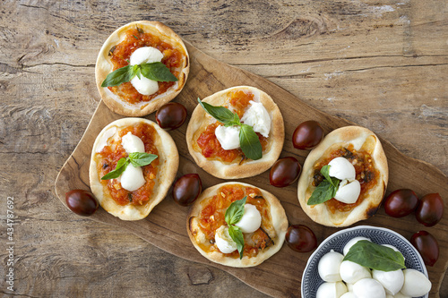 Homemade mini pizzas margarita with tomato, mozzarella and basil photo