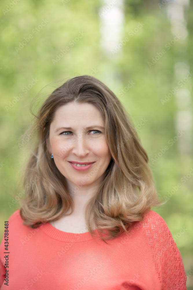 Portrait of a young beautiful blonde woman in a summer forest.