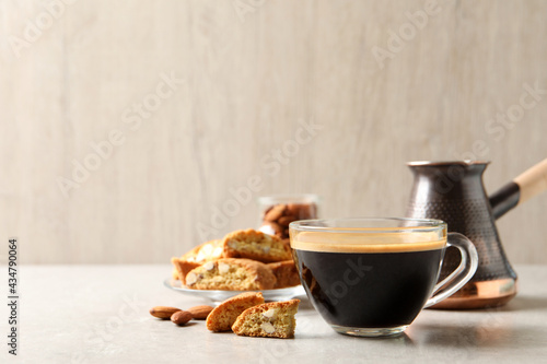 Tasty cantucci and cup of aromatic coffee on light grey table, space for text. Traditional Italian almond biscuits