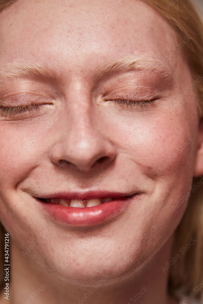 Man with feminine appearance and blonde hair posing at camera with closed eyes Man with feminine appearance and blonde hair posing at camera with closed eyes