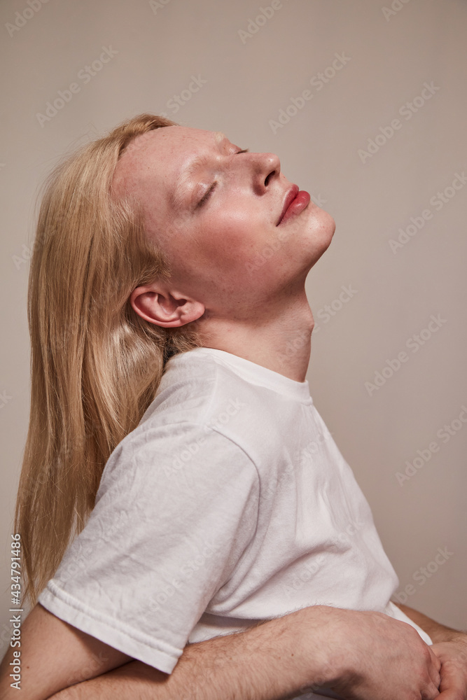 Serene albino and blonde long haired guy posing with closed eyes Serene albino and blonde long haired guy posing with closed eyes