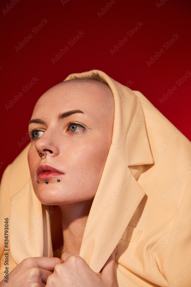 Female with masculine appearance wearing stylish jacket at her head Female with masculine appearance wearing stylish jacket at her head
