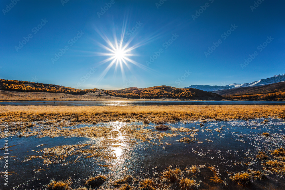 View of Lake Dzhangyskol in the Yeshtykel tract with grass covered with morning frost. Russia, Altai Republic. View of Lake Dzhangyskol in the Yeshtykel tract with grass covered with morning frost. Russia, Altai Republic.