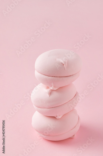 Stack of round pink marshmallows on pastel pink background, close-up. Three sweet zephyr candies for postcard.