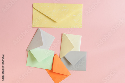 Paper envelopes of different colors on a pink background. View from above © Tinka Mach