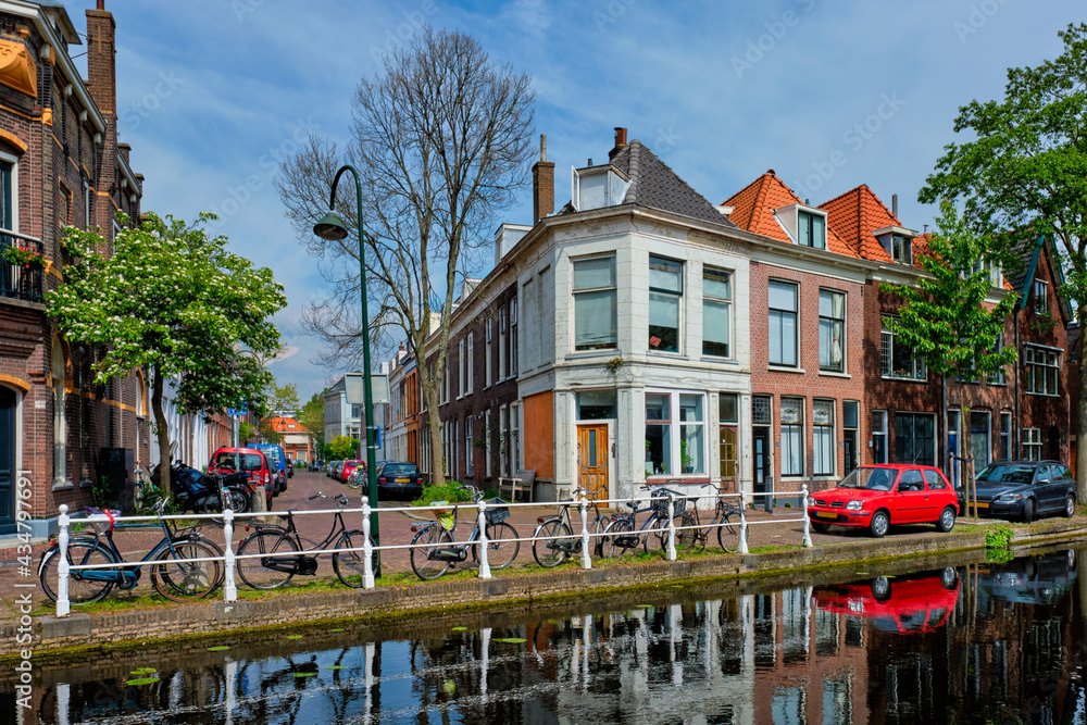 Cars on canal embankment in street of Delft. Delft, Netherlands