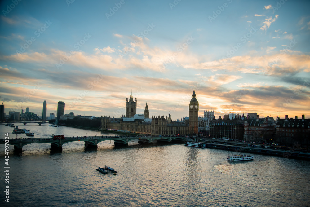 London, UK - February 4, 2017: London skyline view at sunset with famous landmarks, Big Ben, Houses of Parliament and ships on River Thames with beautiful blue and yellow sky.