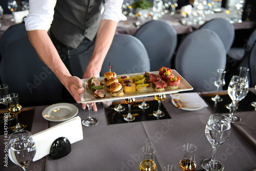 Man serving snacks to pair with whiskey taste. Whiskey and food pairing. © Oskars