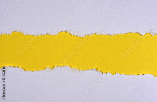 Ripped in white paper on yellow background