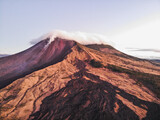 vista aérea campo de lava seca drenando del Volcán de Pacaya cubierto de nubes y expulsando material piroclástico