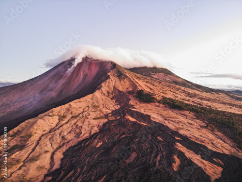 vista aérea campo de lava seca drenando del Volcán de Pacaya cubierto de nubes y expulsando material piroclástico