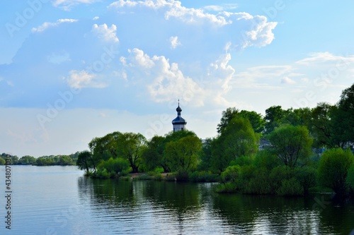 The dome of the church against the backdrop of the river and green trees