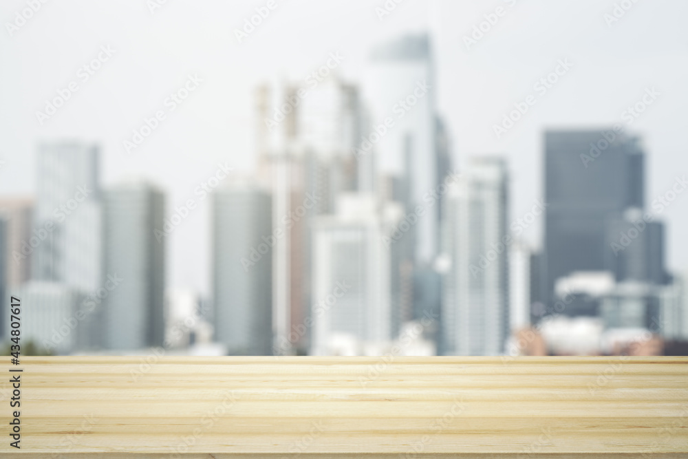 Blank tabletop made of wooden planks with beautiful blurry cityscape in the afternoon on background, mockup