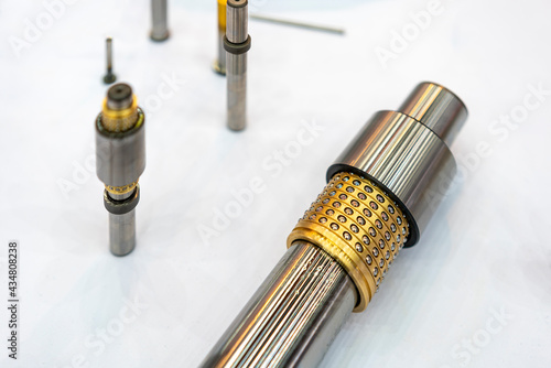 Metal alloy copper or brass oilless or oil free bush with embedded solid lubricant assemble with cylinder shaft equipment for mold or stamping die system in industrial on table