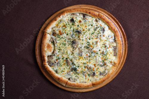 view from above pizza with cheese, mushrooms and herbs on a thick dough