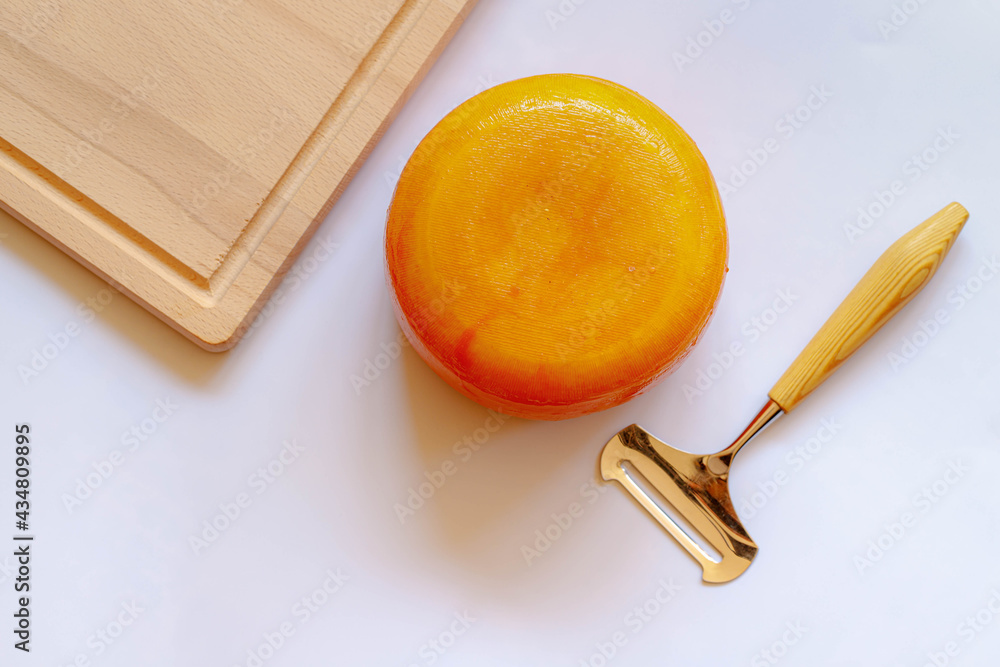 Foto Stock Gouda cheese (Goudse kaas) with wooden board and cutter on